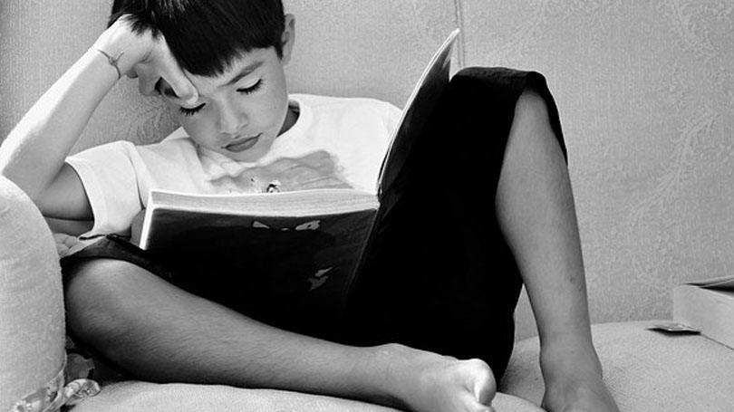 Child sitting reading after domestic violence and child abuse