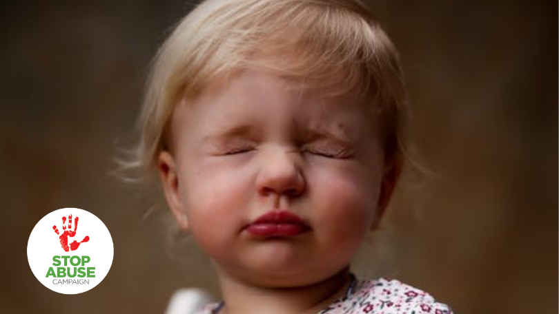 A small child with their eyes shut tight, in an attempt to hide, indicating an article on parental mental illness as an ACE.