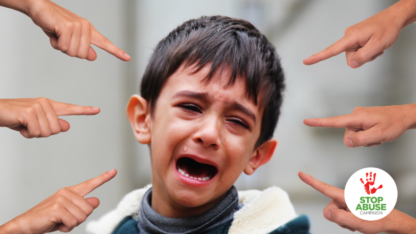 A photo of a crying boy, with a lot of fingers pointing at him, indicating an article on mental health stigma and its effects and prevention.